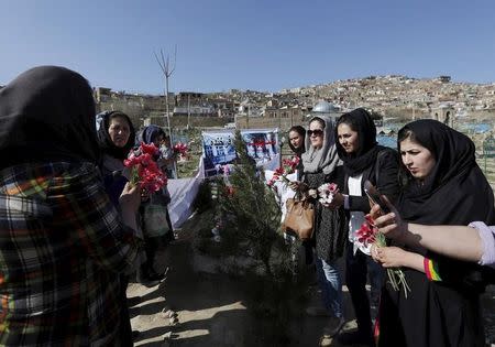 Afghan women's rights activists hold flowers as they gather at the grave of 27-year-old Farkhunda in Kabul March 26, 2015. REUTERS/Mohammad Ismail