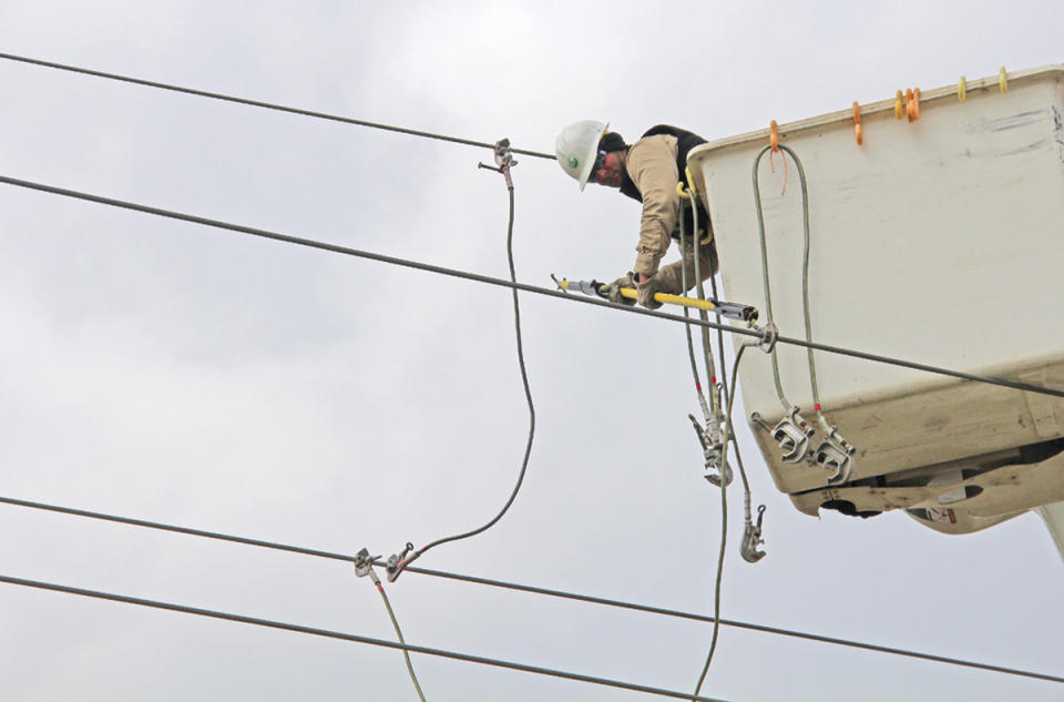 Coty Cox, an employee of Craighead Electric Cooperative, finishes replacing one of the downed power lines along Lacy Drive in Jonesboro, Ark., Saturday, March 25, 2017. Storms demolished mobile homes in Arkansas and a church in Louisiana as a menacing weather system threatened several states across the South and Midwest, authorities said. (Staci Vandagriff/The Jonesboro Sun via AP)