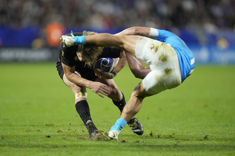 New Zealand's Damian McKenzie, left, is challenged by Uruguay's Nicolas Freitas during the Rugby World Cup Pool A match between New Zealand and Uruguay at the OL Stadium, in Lyon, France Thursday, Oct. 5, 2023. (AP Photo/Pavel Golovkin)