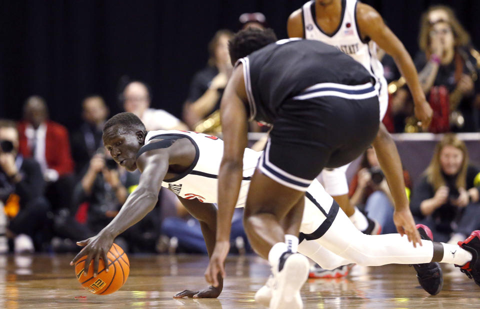 San Diego State forward Aguek Arop, left, dives for the ball in front of Utah State guard RJ Eytle-Rock during the first half of an NCAA college basketball game for the men's Mountain West Tournament championship Saturday, March 11, 2023, in Las Vegas. (AP Photo/Steve Marcus)