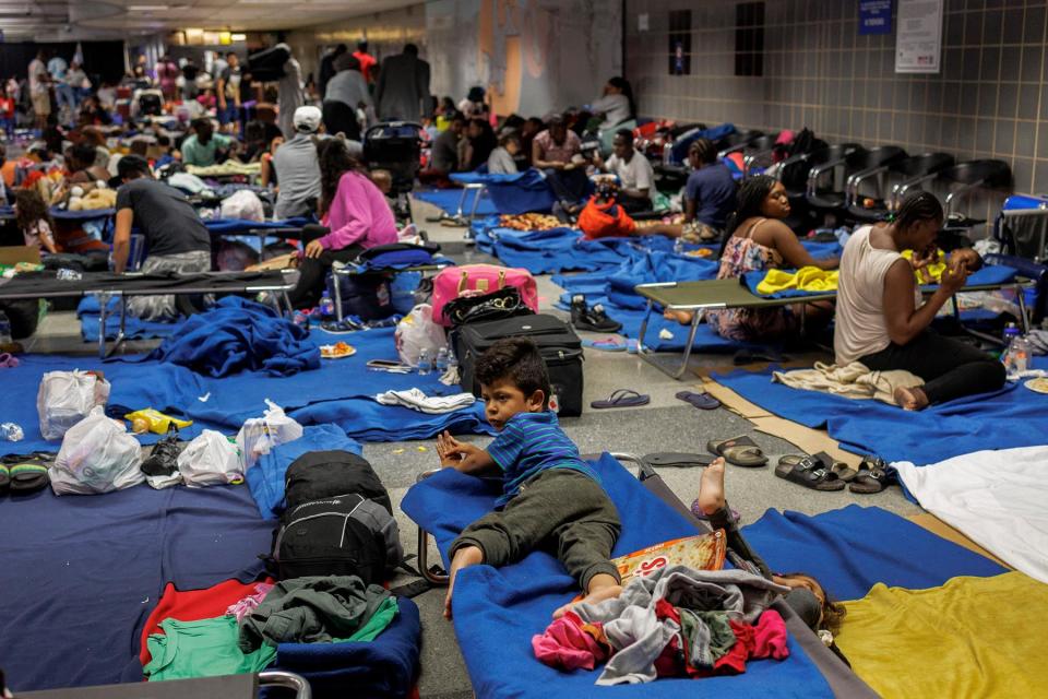 Recently arrived migrants sit on cots and the floor of a makeshift shelter operated by the city at O'Hare International Airport on Aug. 31, 2023. (Armando L. Sanchez/Chicago Tribune/Tribune News Service via Getty Images)