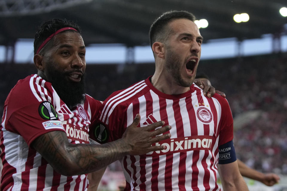 Olympiaco's Kostas Fortounis, right, celebrates with his teammate Olympiacos' Rodinei after scoring against Fenerbahce during the Europa Conference League quarter final first leg soccer match between Olympiacos and Fenerbahce at the Georgios Karaiskakis stadium, Piraeus port near Athens, Greece, Thursday, April 11, 2024. (AP Photo/Thanassis Stavrakis)