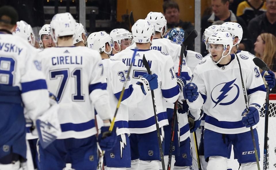 FILE - Tampa Bay Lightning's Cameron Gaunce (33) celebrates with teammates after defeating the Boston Bruins in an NHL hockey game in Boston, Saturday, April 6, 2019. The Boston Bruins are chasing the records for the most wins and points in an NHL regular season. Members of the 1976-77 Montreal Canadiens, '95-96 Detroit Red Wings and 2018-19 Tampa Bay Lightning who hold one or both of them know what it’s like to be that dominant and see plenty of parallels between what they accomplished and what the Bruins are doing. (AP Photo/Michael Dwyer, File)