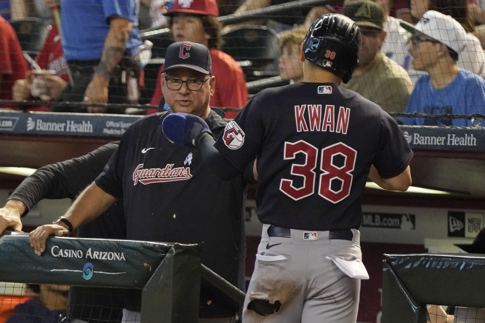 Cleveland Guardians manager Terry Francona, left, gives a high-five to Steven Kwan (38) after Kwan scored the team's first run against the Arizona Diamondbacks during the first inning of a baseball game Sunday, June 18, 2023, in Phoenix. (AP Photo/Darryl Webb)