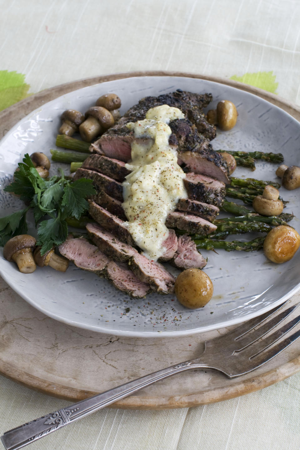 In this image taken on March 11, 2013, grilled lamb steaks with artichoke lemon sauce are shown served on a plate in Concord, N.H. (AP Photo/Matthew Mead)