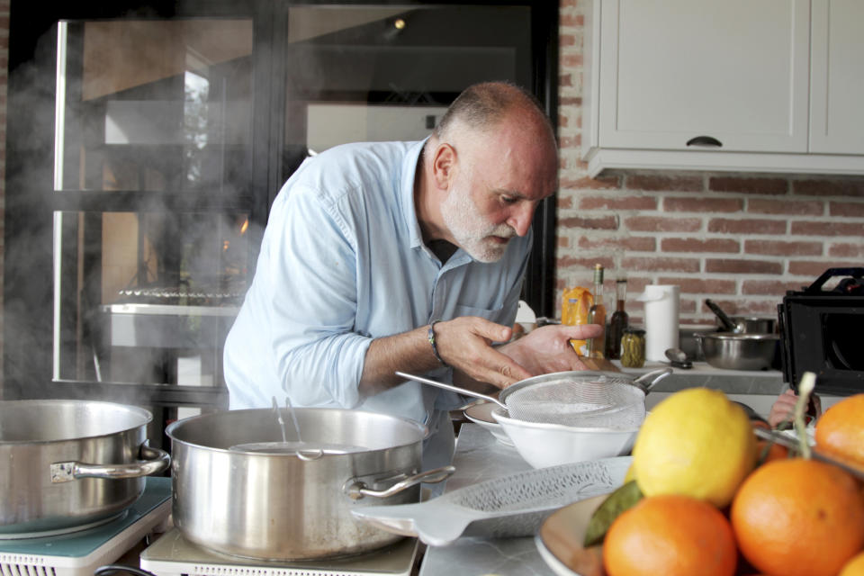 This image provided by Discovery shows host Jose Andres in the kitchen cooking for his family and friends in Asturias in a scene from the Discovery + television series "Jose Andres and Family in Spain." (Discovery via AP)