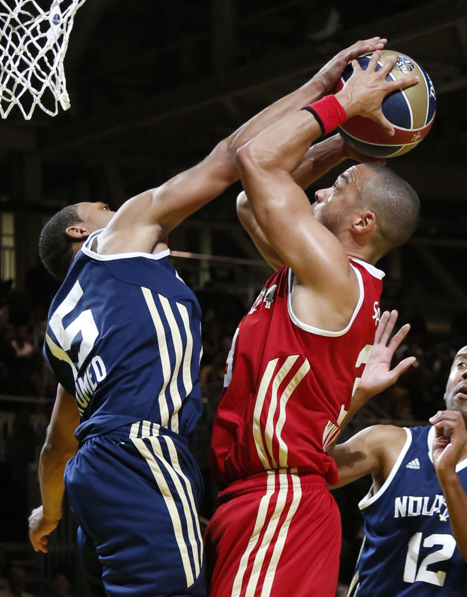 East's Romeo Miller (15) blocks the shot of West's Jesse Williams (3) in the second half as they participate in the NBA All-Star Celebrity basketball game in New Orleans, Friday, Feb. 14, 2014. East won 60-56. (AP Photo/Bill Haber)