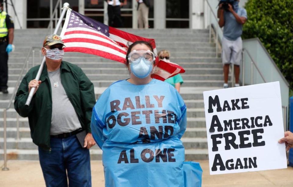 Amber Brown, a health care provider from Greensboro, stands as a counter protester during the ReOpen NC protest in downtown Raleigh, N.C., Tuesday, April 21, 2020.