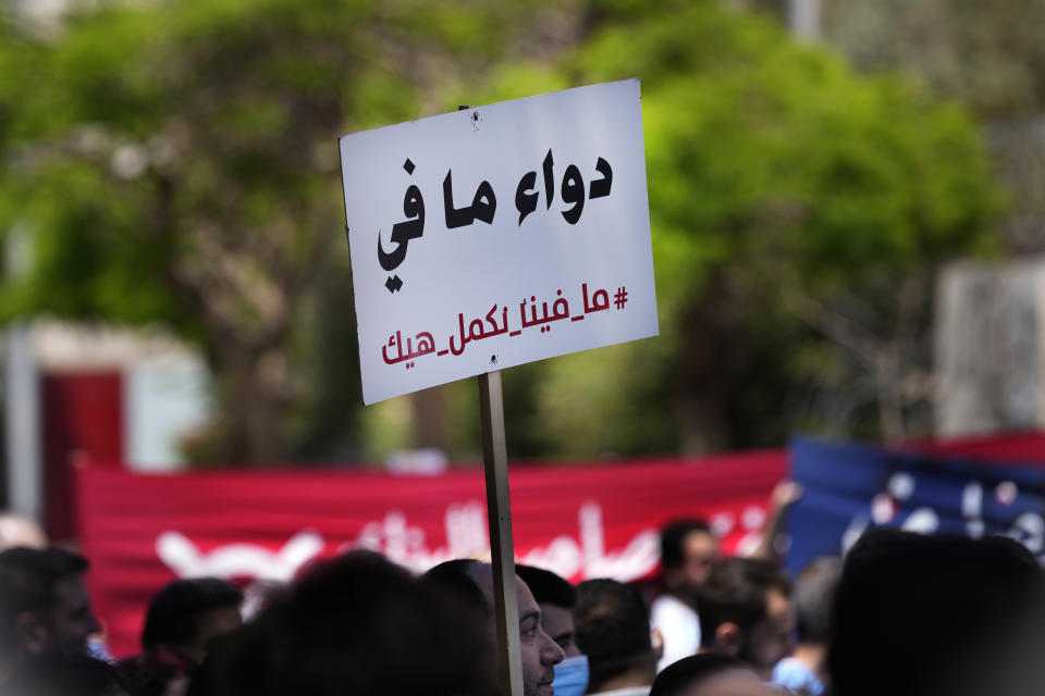 A medical worker holds an Arabic placard that reads: "No medics, we cannot continue like this," as he protests with doctors the deteriorating economic conditions, outside the Central Bank, in Beirut, Lebanon, Thursday, May 26, 2022. The syndicates of doctors in Beirut and the North as well as the Syndicate of Private Hospital Owners declared a two-day general strike Thursday and Friday. (AP Photo/Hussein Malla)