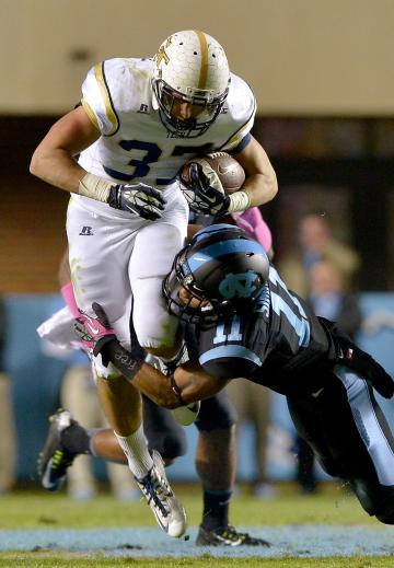 CHAPEL HILL, NC - OCTOBER 18:  Malik Simmons #11 of the North Carolina Tar Heels tackles Zach Laskey #37 of the Georgia Tech Yellow Jackets during their game at Kenan Stadium on October 18, 2014 in Chapel Hill, North Carolina.  (Photo by Grant Halverson/Getty Images)