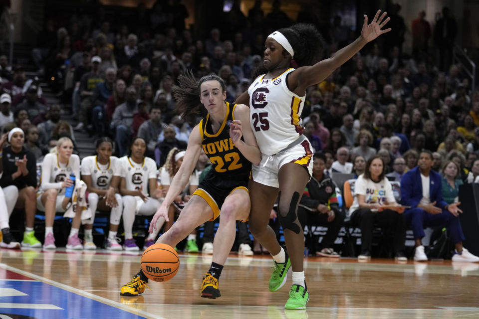 Iowa guard Caitlin Clark (22) drives past South Carolina guard Raven Johnson (25) during the first half of the Final Four college basketball championship game in the women's NCAA Tournament, Sunday, April 7, 2024, in Cleveland. (AP Photo/Carolyn Kaster)