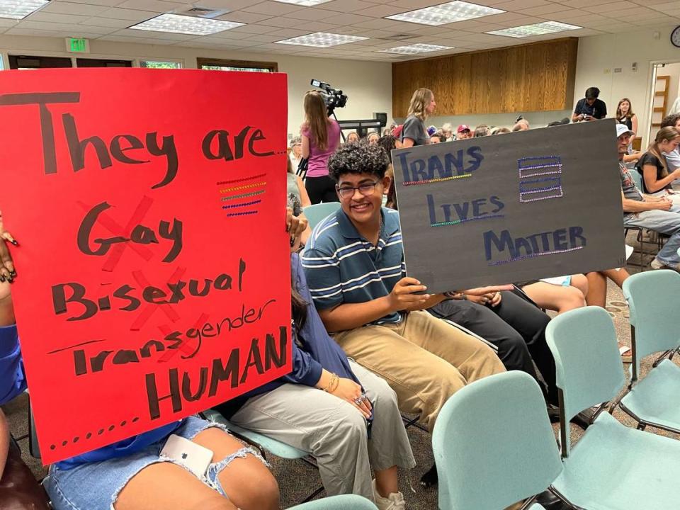 Members of the audience hold signs supporting LGBTQ+ students at the Paso Robles school board meeting on Tuesday, Aug. 23, 2022. The board approved a resolution protecting traditional, gender-specific titles.