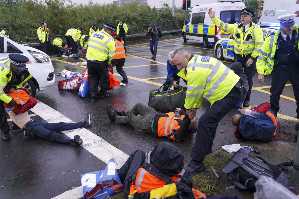 Police officers detain a protester from Insulate Britain occupying a roundabout leading from the M25 motorway to Heathrow Airport in London. Picture date: Monday September 27, 2021. (Photo by Steve Parsons/PA Images via Getty Images)