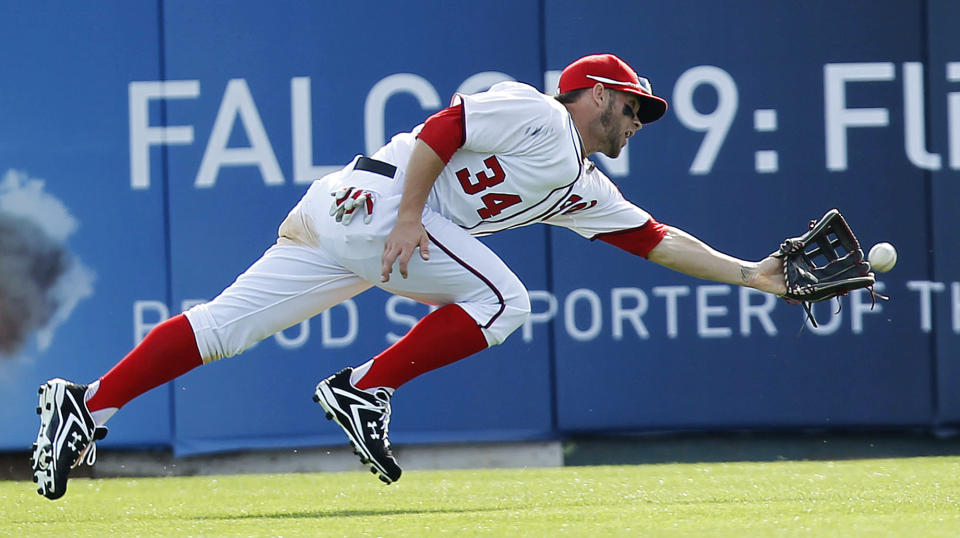 Washington Nationals outfielder Bryce Harper is unable to make the catch on a ball hit by Houston Astros' Brian Bixler in the eighth inning of a spring training baseball game, Sunday, March 4, 2012, in Viera, Fla. (AP Photo/Julio Cortez)