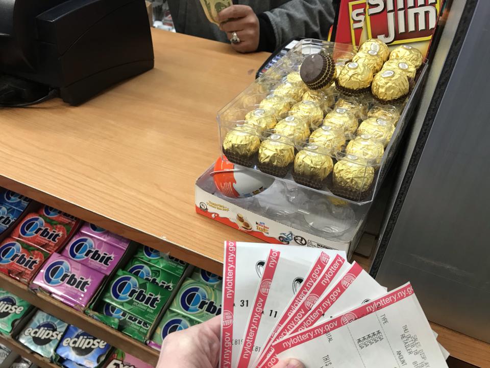 Mega Millions customer purchases jackpot tickets Thursday, Oct. 18, 2018 in New York City