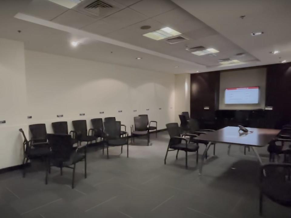 a room with chairs and a digital whiteboard
