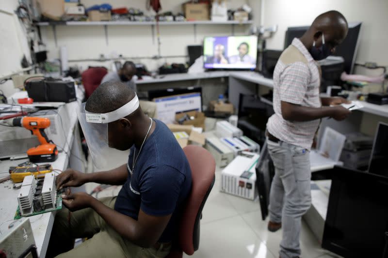 A technician fixes an inverter at an electrical supply store in Port-au-Prince