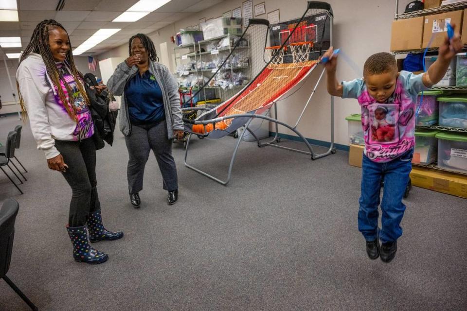 Marquisha Brown, left, and her Yolo Basic Income program caseworker Monique Johnson, center, share giggles as Brown’s son Elijah Washington, 6, jumps rope at the nonprofit Yolo County Children’s Alliance family resource center in West Sacramento in March. Brown said the YOBI program has helped her spend time with Elijah to help him recover from being brutally beaten and witnessing his sister’s death.