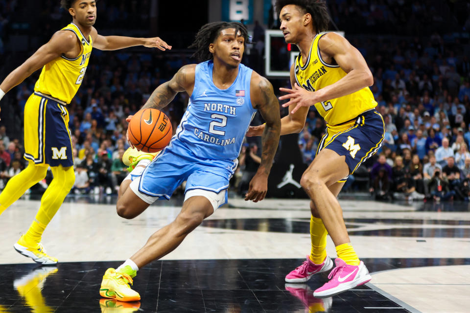 CHARLOTTE, NC - DECEMBER 21: Caleb Love (2) of the North Carolina Tar Heels drives on Kobe Bufkin (2) of the Michigan Wolverines during the Jumpman Invitational on December 21, 2022 at Spectrum Center in Charlotte, NC.  (Photo by David Jensen/Icon Sportswire via Getty Images)