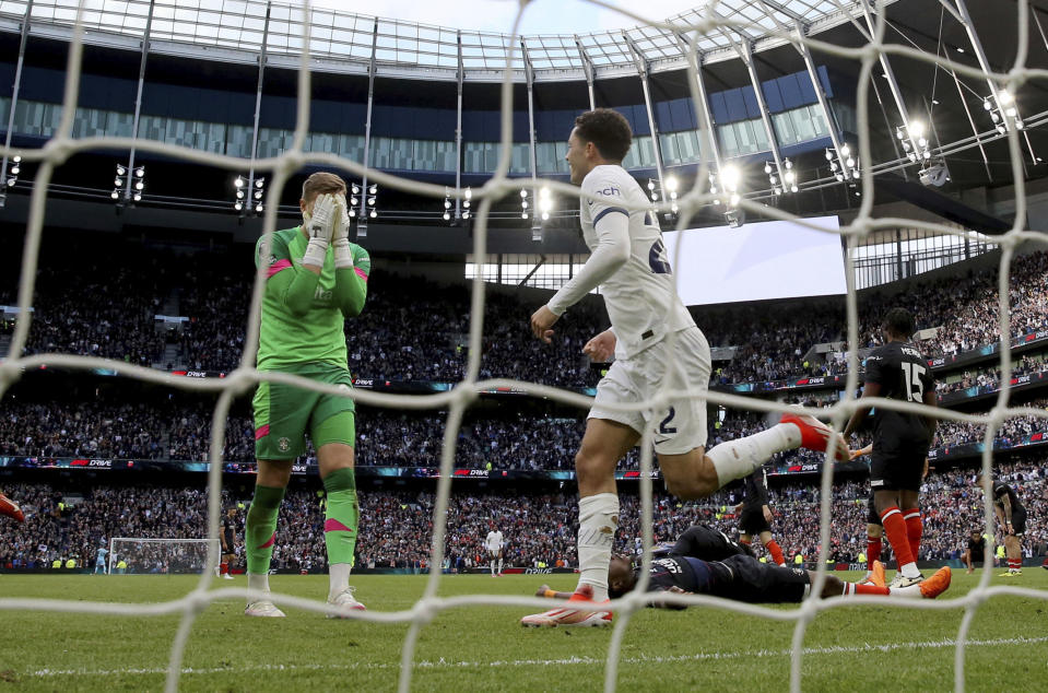 Luton Town goalkeeper Thomas Kaminski, left, reacts after missing second goal during the English Premier League soccer match between Tottenham Hotspur and Luton Town at the Tottenham Hotspur Stadium, London, Saturday, March 30, 2024. (Steven Paston/PA via AP)