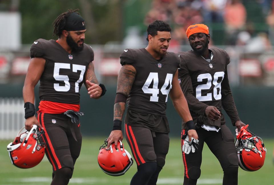 Cleveland Browns linebacker Jeremiah Owusu-Koramoah (28) chats with Cleveland Browns linebacker Sione Takitaki (44) and Cleveland Browns defensive end Romeo McKnight (57) during NFL football practice, Tuesday, Aug. 10, 2021, in Berea, Ohio.