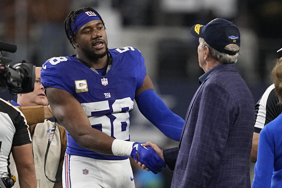 New York Giants linebacker Bobby Okereke (58) shakes hands with former President George W. Bush, right, before an NFL football game between the New York Giants and the Dallas Cowboys, Sunday, Nov. 12, 2023, in Arlington, Texas. (AP Photo/Tony Gutierrez)