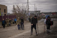 People with disabilities and injured soldiers walk after crossing the Irpin river on the outskirts of Kyiv, Ukraine, Saturday, March 5, 2022. (AP Photo/Emilio Morenatti)