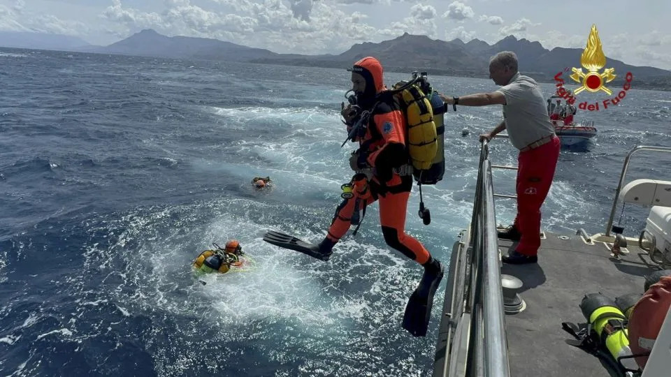 Divers jump into the sea to search for six people missing in Sicily, southern Italy, on Monday. - Handout/Vigili del Fuoco/Reuters