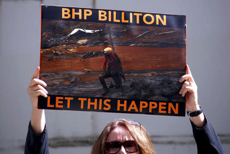 FILE PHOTO - A protester holds a placard regarding the Samarco mine disaster outside the venue for the annual general meeting for mining company BHP Billiton in Perth, Western Australia, November 19, 2015. REUTERS/David Gray/File photo