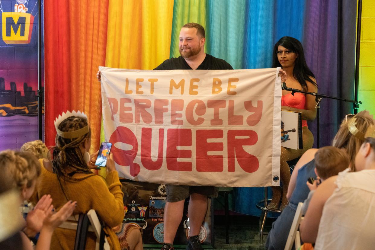 Adam Miller, founder of Drag Queen Story Time Kentucky, holding a flag at Carmichael's Bookstore on Frankfort Avenue. Drag queen story times have been targeted by hate groups around the nation and here in Columbus.