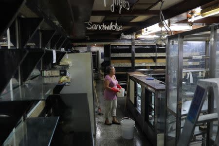 Una mujer parada dentro de una panadería que fue saqueada en medio de las protestas en contra del presidente venezolano Nicolás Maduro en la ciudad de Los Teques, cerca de Caracas, Venezuela, 19 de mayo de 2017. REUTERS/Carlos Barria