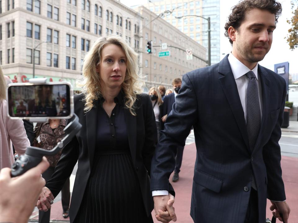 Elizabeth Holmes walking into courthouse while holding hands with Billy Evans