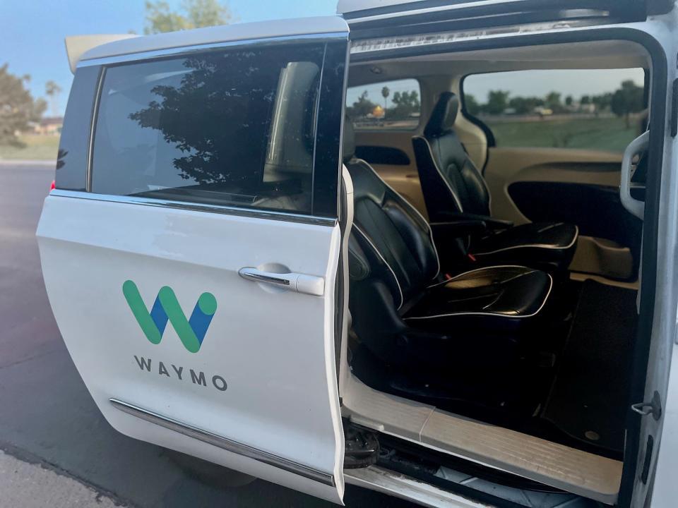 The white Waymo car with the door open.