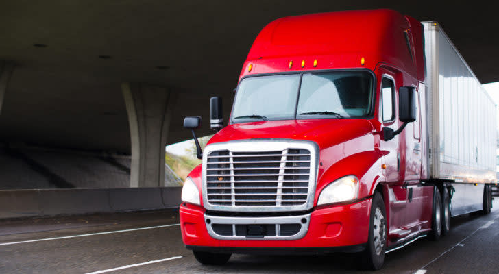 a red 18-wheeler truck driving down the highway