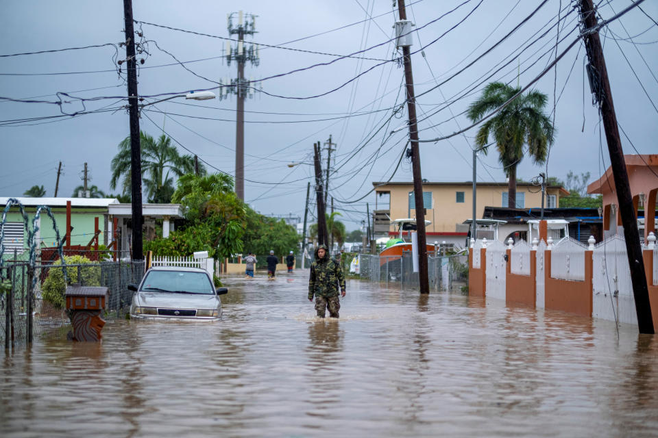 <p>A member of the Puerto Rico National Guard wades through water in search for people to be rescued from flooded streets in the aftermath of Hurricane Fiona in Salinas, Puerto Rico September 19, 2022. REUTERS/Ricardo Arduengo</p> 