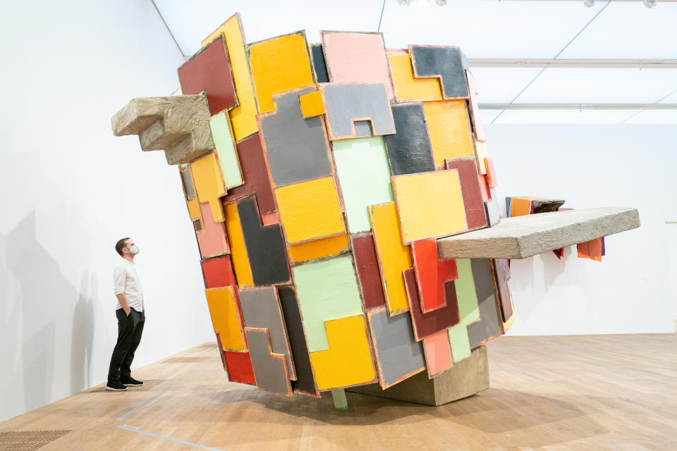 <p>A member of Tate Modern staff views 'untitled: upturnedhouse2' during a photocall for Artist Rooms: Phyllida Barlow, the latest in a series of free displays at the Tate Modern in London. Picture date: Monday August 23, 2021.</p>
