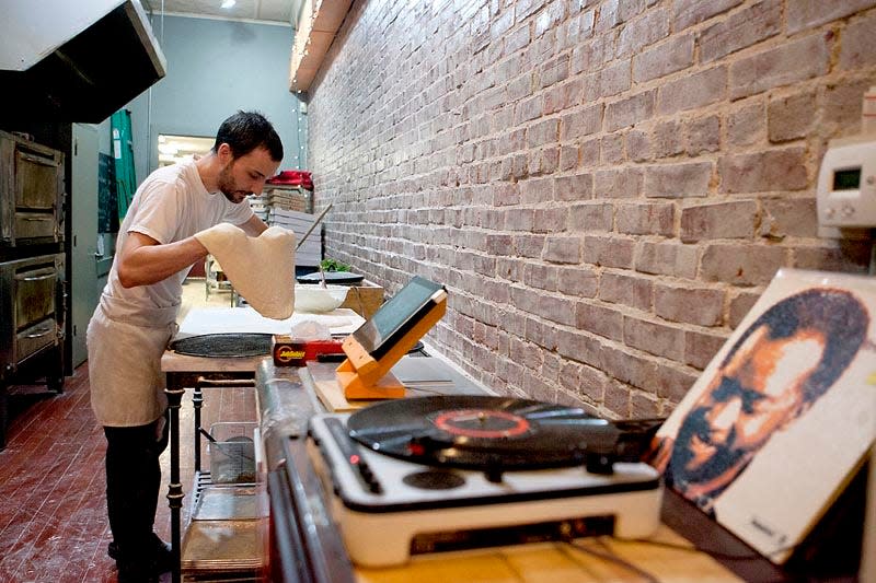 Baked Pizza owner Kevin Prow prepares an Uncle Punk's Tomato pizza.