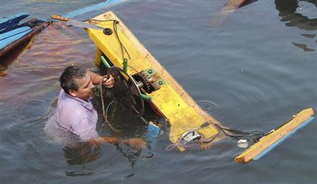 A fisherman tries to salvage his boat in the aftermath of an earthquake and tsunami that hit the northern port of Iquique, April 2, 2014. REUTERS/Francisco Alcayaga Motta