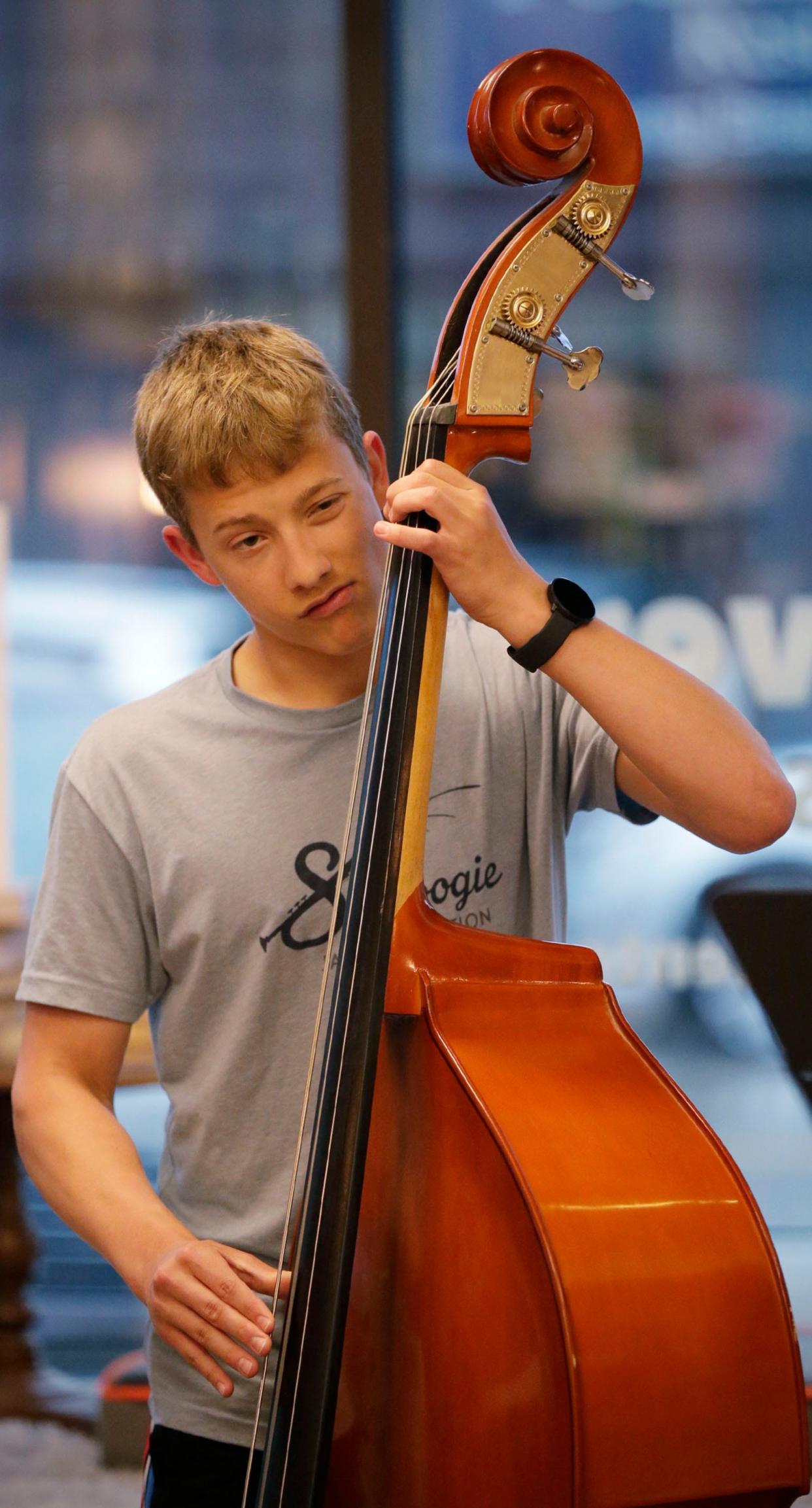 George Phillips, of Sheboygan, reacts to a note on his string bass during a jazz jam session at WordHaven BookHouse, Wednesday, April 19, 2023, in Sheboygan, Wis.