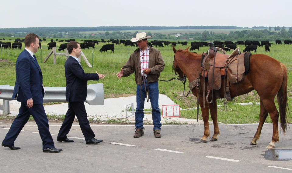 Russian Prime Minister Dmitry Medvedev, second left, shakes hands with a farmer as he visits cattle breeding farm Kotlyakovo in Bryansk region, 380 km (238 miles) southwest of Moscow, Russia, Wednesday, May 23, 2012. (AP Photo/RIA-Novosti, Yekaterina Shtukina, Presidential Press Service).