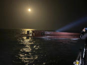 In this photo provided by South Korea's Mokpo coast guard, members of the South Korean coast guard search for people from a capsized boat in waters off the country's southwestern coast, South Korea, Sunday, Feb. 5, 2023. South Korean coast guard vessels and aircraft were searching on Sunday in waters off the country's southwestern coast for nine fishermen who disappeared after their boat capsized. (South Korea's Mokpo coast guard via AP)