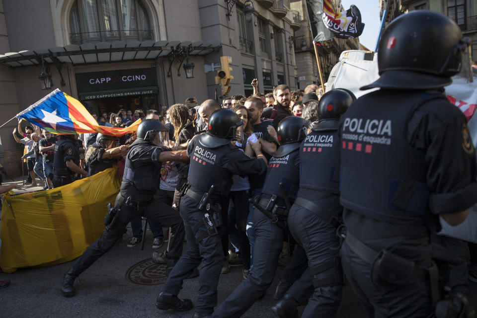 Catalan police officers clash with pro independence demonstrators on their way to meet a demonstrations by member and supporters of National Police and Guardia Civil in Barcelona on Saturday, Sept. 29, 2018. (AP Photo/Emilio Morenatti)