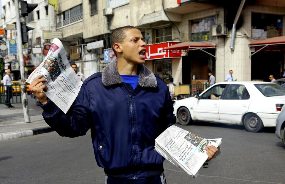 A Palestinian vendor shouts as he sells Al-Quds Newspaper on the first day of its arrival to Gaza from the West bank since being banned by Hamas in 2008, in Gaza City, in the northern Gaza Strip, Wednesday, May 7, 2014. Gaza’s Hamas rulers on Wednesday permitted a veteran West Bank newspaper to be distributed in the coastal territory for the first time in six years, taking a new step toward implementing a reconciliation deal with the rival West Bank government. (AP Photo/Adel Hana)