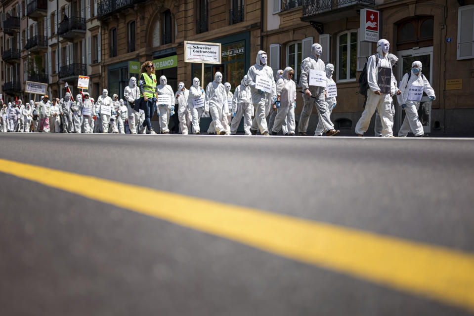 FILE - People demonstrate during the "Stiller Protest" (silent protest) association march to protest against anti-COVID measures, in Neuchatel, Switzerland, May 22, 2021. Switzerland is facing an exponential rise in coronavirus cases. But its federal government, hasn't responded with new lockdown measures. Experts say that's because the government's anti-COVID policies face a crucial test at the ballot box. On Sunday Nov. 28, 2021, Swiss voters will cast ballots on a ‚COVID-19 law' that has unlocked billions of Swiss francs in aid for workers and businesses hit by the pandemic. (Valentin Flauraud/Keystone via AP, File)