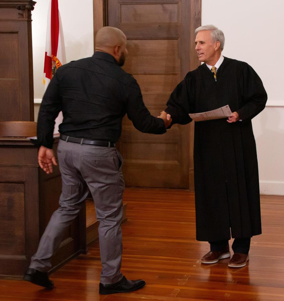 U.S. Magistrate Judge Christopher Tuite congratulations one of the new citizens who took part in a naturalization  ceremony Friday morning at the Polk History Center in Bartow. About 30 applicants gained citizenship in each of two ceremonies.