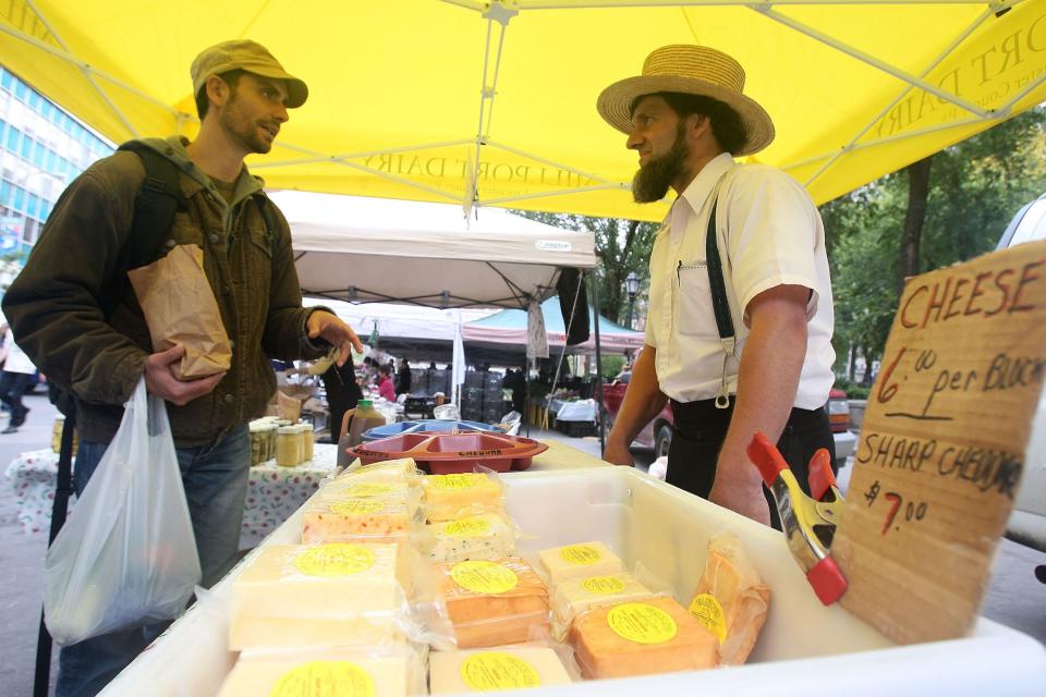 Amish farmer John Stoltzfoos talks with a customer at the Union Square farmers market October 2, 2009 in New York City.