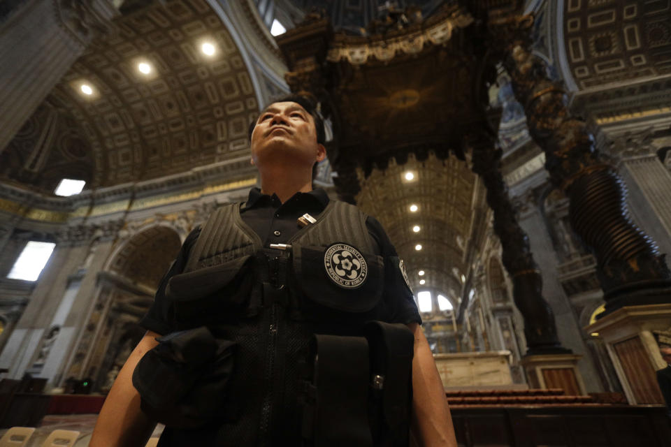 A South Korean presidential security guard walks in side St. Peter's Basilica prior to the start of a mass for Peace celebrated by Vatican Secretary of State Pietro Parolin and attended by South Korean President Moon Jae-in and his wife Kim Jung-sook at the Vatican, Wednesday, Oct. 17, 2018. South Korea's president is in Italy for a series of meetings that will culminate with an audience with Pope Francis at which he's expected to extend an invitation from North Korean leader Kim Jong Un to visit. (AP Photo/Gregorio Borgia)