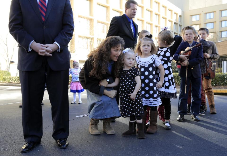 FILE - In this March 14, 2014 file photo, Rev. Mark Harris, left, who is seeking a Republican U.S. Senate nomination in the upcoming North Carolina primary, was supported during a campaign event by Michelle Duggar, kneeling, and Jim Bob Duggar, back right, and many of the Duggar's 19 children, in Raleigh, N.C., The Duggars star in a reality TV show. (AP Photo/Ted Richardson)