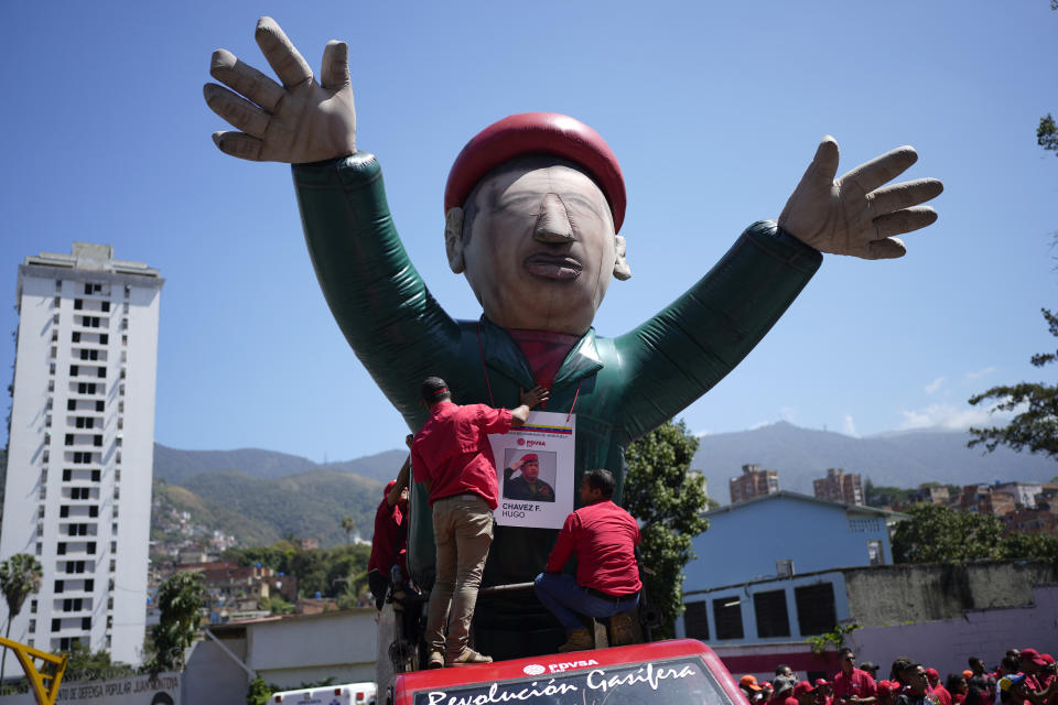 Supporters of late Venezuelan President Hugo Chavez prepare a giant inflatable doll of the former president during commemorations marking the tenth anniversary of his death, in Caracas, Venezuela, Sunday, March 5, 2023. Chavez died on March 5, 2013, after a long battle with cancer and chose current president, Nicolas Maduro, a former bus driver and union leader to be his successor. (AP Photo/Ariana Cubillos)