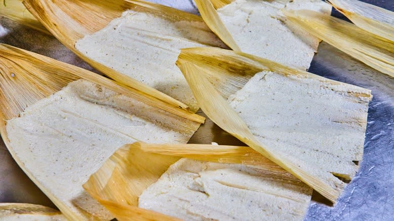 Masa spread in cornhusks for tamales